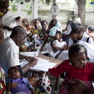 A community health worker documents the weight of children at a health centre in Kinshasa, DRC