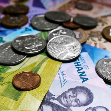 Photo of Ghanaian cedi notes and coins currency scattered on table