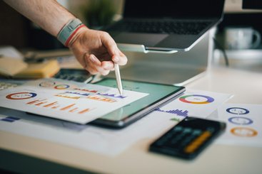 A hand pointing at a graph using a pen